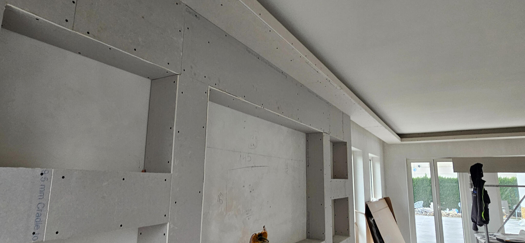 TV-wand met verlichtingskoof — S GYPFIX Lievegem Gipsplaten TV-wand met rekken en geïntegreerde verlichtingskoof bovenaan - S GYPFIX Lievegem