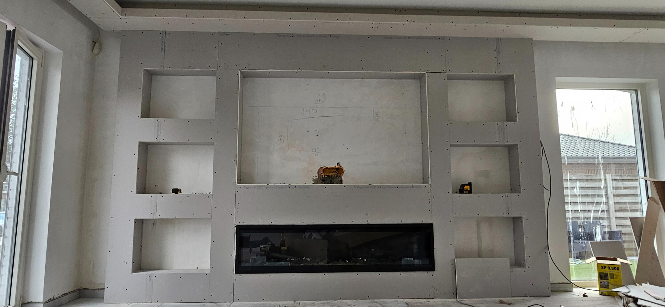 Volledige TV-wand met rekken en haardnis — Lievegem Grote gipsplaten wandconstructie met meerdere rekken, haardnis en verlichtingskoof - S GYPFIX Lievegem